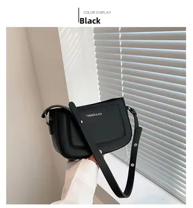 Detail of black leather shoulder bag with FASHION & RYX logo and adjustable strap