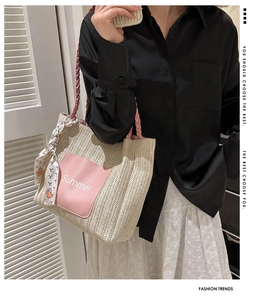 Detail der gewebten Stroh-Tote-Bag mit rosa Lederpatch und dekorativem Seidenschal