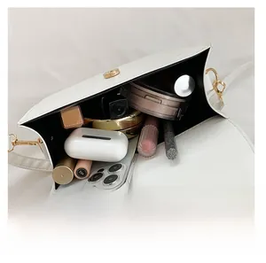 Internal storage view of white crocodile pattern crossbody bag with golden hardware