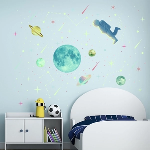 Detailed wall view of luminous astronaut and moon stickers in a blue kids bedroom decor