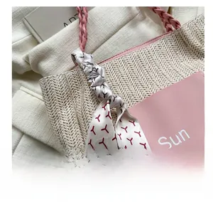 Detail der Strohtasche mit Summer-Patch, rosa Griffen und dekorativem Seidenschal