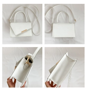 Detailed views of a white crocodile pattern handbag with gold hardware and interior space