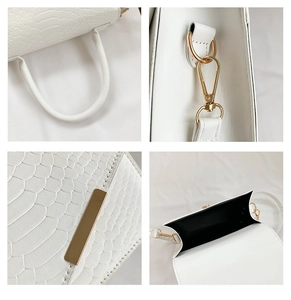 Close-up of white crocodile pattern texture with golden hardware and stitching details