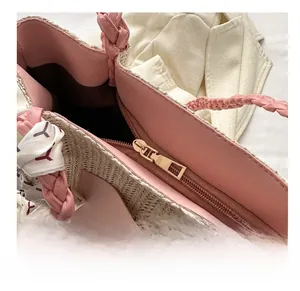 Detail der rosa Strohtasche mit glattem Goldreißverschluss und dekorativem Seidenschal