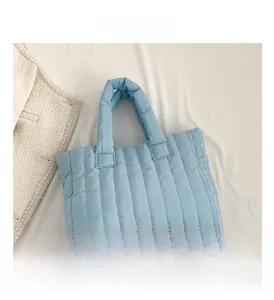 Detailed close-up of sky blue quilted tote bag showing nylon texture and vertical seams