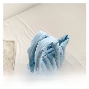 Detailed close-up of light blue quilted puffer tote bag with soft padded handles
