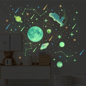 Luminous wall stickers featuring moon, planets and astronauts in a dark bedroom setting