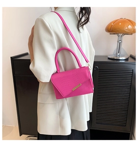 Magenta faux crocodile leather handbag worn as a stylish crossbody bag with gold hardware