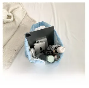 Spacious light blue quilted tote bag showing interior storage for tablets and gadgets
