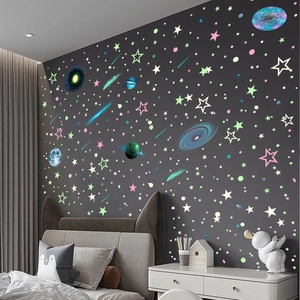 Luminous solar system wall stickers with glowing stars and moon in a dark bedroom