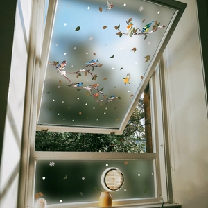 Colorful birds and snow-covered branches static window clings on white glass frame
