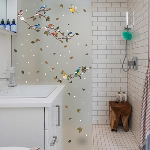 Modern bathroom decor showing colorful bird and branch static window film on glass