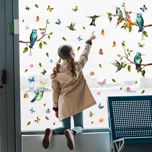 Detail of colorful hummingbird and butterfly static cling stickers on a glass window