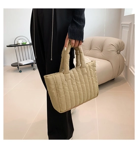 Detailed side view of khaki quilted tote bag showing padded handles and nylon texture
