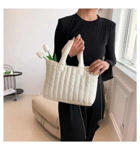 Detail of off-white quilted puffer tote bag featuring soft vertical stitched stripes
