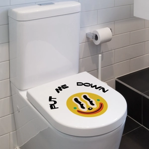 Sticker couvercle de toilette clown souriant avec texte 'PUT ME DOWN' dans salle de bain