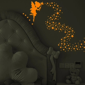 Detail view of glowing fairy and star wall stickers shining in a dark bedroom