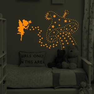 Detailed view of luminous glowing fairy and stars wall stickers in a dark kids bedroom
