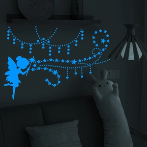 Luminous wall stickers featuring fairy and star silhouettes glowing bright blue in the dark