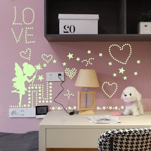 Luminous wall sticker set with glowing stars and fairy on a warm bedroom wall