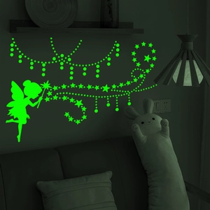 Luminous fairy and stars wall stickers glowing in a dark bedroom setting