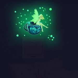 Detailed close-up of a glowing fairy and star wall sticker on a light switch panel