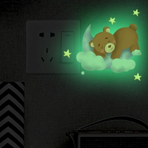 Luminous wall stickers showing a sleeping bear on a moon with stars in the dark