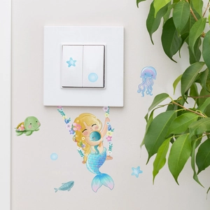 Detailed view of luminous mermaid and sea turtle wall stickers around a light switch
