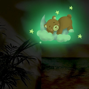 Luminous wall stickers showing a glowing cartoon bear on a moon with stars in the dark