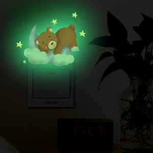 Glow-in-the-dark sleeping bear on moon wall decal with luminous stars around light switch