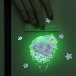 Luminous wall stickers set showing a glowing moon and stars near a light switch