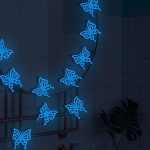 Luminous blue 3D hollow butterfly wall stickers glowing on a mirror in a dark room decor