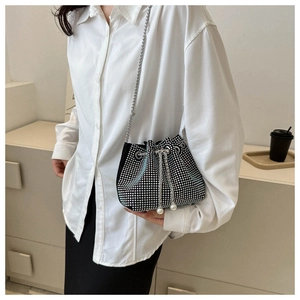 Détail du sac seau noir avec strass scintillants, bandoulière chaîne et perles