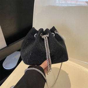 Gros plan du sac seau noir en strass avec chaînes argentées et breloques en perles