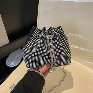 Détail du sac seau à strass avec chaîne argentée et perles blanches sur le cordon