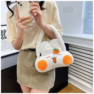 Dettaglio della borsa in peluche bianca con ricamo di animali e decoro a fragola