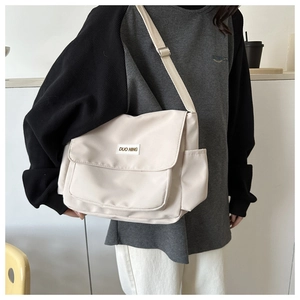 Dettaglio della borsa a tracolla in nylon bianco sporco con grande capacità e logo