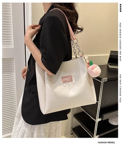 White PU leather tote bag with pink chain strap and peach plush charm detail