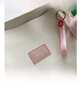 Detail of lychee pattern beige tote bag with pink Fashion Instinct leather label