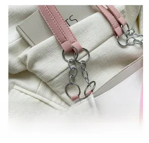 Detail of silver chain link and pink leather strap on a white PU shoulder tote bag