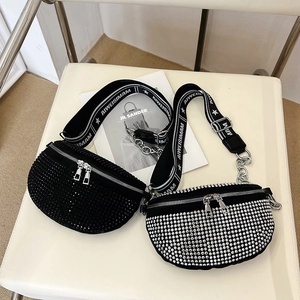 Sparkling rhinestone crossbody bag with chain detail and wide strap on white chair