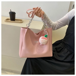 Pink PU leather tote bag detail with fashion logo tag and peach plush charm hanging