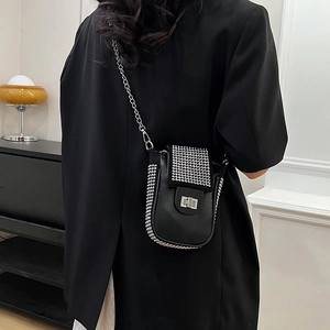 Chic black crossbody phone bag with sparkling rhinestone decor and chain strap worn by model
