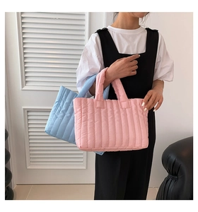 Detail van gewatteerde draagtas in roze en lichtblauw gewatteerd nylon voor dames