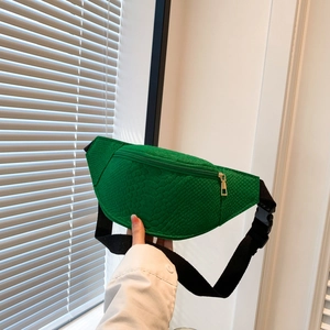 Detail of green faux crocodile texture and gold zipper on a half-moon chest bag