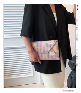 Detailaufnahme einer bunten Zickzack-Briefumschlagtasche mit goldener Metallverzierung