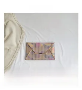 Detail der Briefumschlag-Clutch mit Zickzack-Muster und goldenen Metallkanten auf Stoff