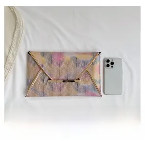 Bunte Umschlag-Clutch mit Zickzack-Muster und Smartphone als Größenreferenz gezeigt