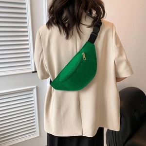 Green snakeskin texture chest bag with adjustable strap worn by model in casual style