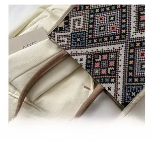 Detail of colorful woven geometric pattern canvas tote bag with brown braided handles